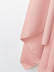 Close-up of an apricot-colored A-line dress featuring a smooth, woven fabric texture.