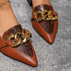 Brown pointed-toe mules featuring a snakeskin-textured panel and a chunky gold-tone chain detail.