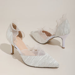 A pair of elegant white pointed-toe stiletto pumps featuring pleated fabric and ruffled trim.