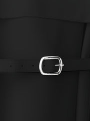 A close-up of a black dress featuring a silver buckle belt at the waist.