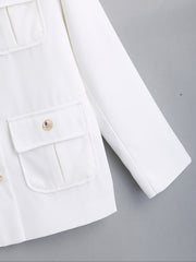 A white long-sleeved luxury coat featuring a buttoned flap pocket on a solid fabric background.