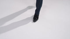 A pair of black patent leather oxford shoes with velvet accents and lace-up closures.