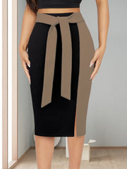 A slim-fit black midi skirt featuring a contrasting tan side panel and an adjustable waist tie.