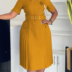 A mustard yellow V-neck dress featuring a belted waist, short sleeves, and a pleated skirt.