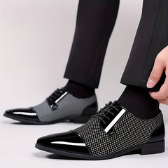 Men's black and white lace-up Oxford dress shoes with a textured pattern and glossy toe cap.