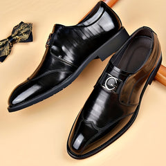 A pair of black pointed-toe loafers with a silver G-shaped buckle and a matching bow tie.