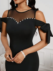 A black bodycon dress featuring a mesh neckline, pearl embellishments, and bow-tie sleeves.
