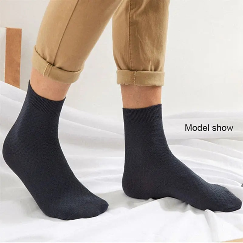 A person wearing black compression bamboo fiber crew socks (10 Pairs/Lot Men's Bamboo Fiber Socks 2022, size 42-45) and rolled-up beige pants stands on a white surface. The text "Model show" appears near the right ankle.