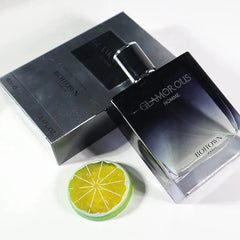 A 100ML OEM/ODM EDP men's perfume with long-lasting fragrance rests beside its box, accented by a decorative lime slice on a white surface.