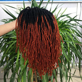 A hand holds the 10Inches Braided Wigs Afro Bob Wig by Yun Rong Hair, featuring synthetic dreadlock braids fading from black roots to reddish-brown tips; a leafy green plant appears in the background.