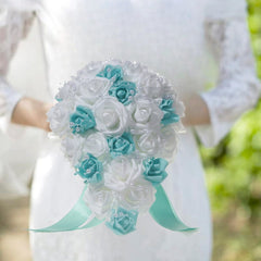 A bridal teardrop bouquet of white and blue silk roses accented with pearls and a ribbon.