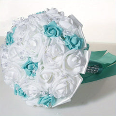 A handmade bridal bouquet of white and blue silk roses accented with pearl strands and ribbons.
