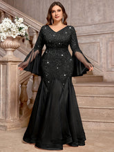 Plus size black sequin and lace V-neck gown with long bell sleeves and a mermaid tulle hem.