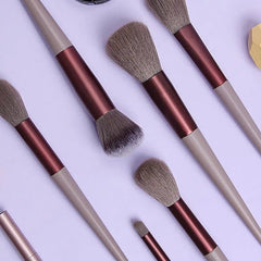 The 13 PCS Makeup Brushes Set features light gray handles, metallic burgundy ferrules, and soft bristles in various sizes and shapes for eye shadow, foundation, blush, and more—perfect beauty tools for women.