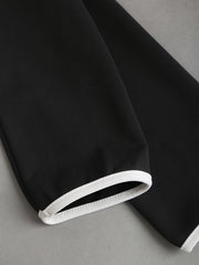 A close-up of a black long sleeve with a white trim at the cuff.