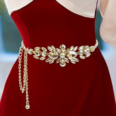 A golden-toned adjustable chain belt featuring a sparkling rhinestone leaf design.