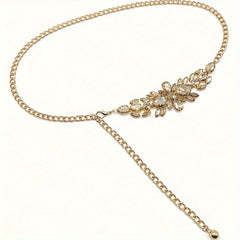 A gold-toned chain belt featuring a decorative cluster of sparkling rhinestones in a leaf pattern.