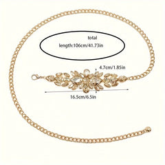 A golden chain belt featuring a central decorative piece with sparkling leaf-shaped rhinestones.