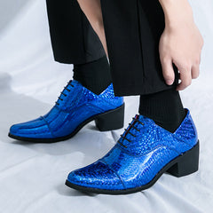A pair of shiny blue faux leather men's dress shoes with a block heel and black laces.