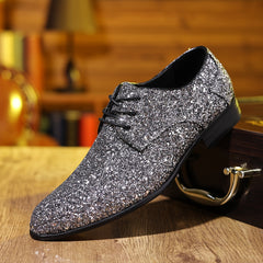 A silver glitter lace-up dress shoe with a pointed toe and black sole.