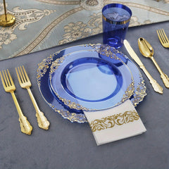 A place setting featuring blue plastic plates with gold rims, gold cutlery, a blue cup, and a napkin.