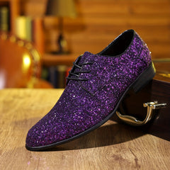 A single purple glitter lace-up dress shoe with a pointed toe rests on a wooden surface.
