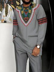 A man wears a grey long-sleeved African-inspired suit with a colorful patterned chest and sleeve.