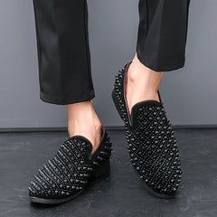A pair of black slip-on loafers for men featuring an all-over spiked texture and rubber soles.