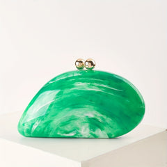 A green marbled acrylic clutch with a smooth, rounded shape and two gold spherical clasps.