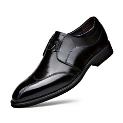 A polished black leather oxford shoe with a pointed toe and a decorative metal accent.