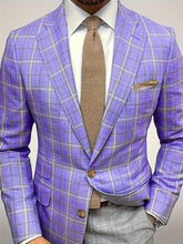 A man wears a lightweight purple checkered blazer with a lapel collar and a tan knit tie.