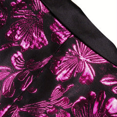 A close-up view of a black suit jacket featuring a vibrant metallic pink paisley pattern.