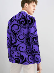 A man wears a slim-fit purple blazer featuring a black geometric swirl pattern and button details.
