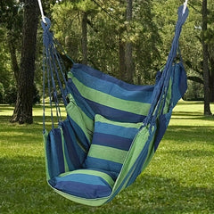 A blue and green striped canvas hammock chair with a matching cushion hanging outdoors.