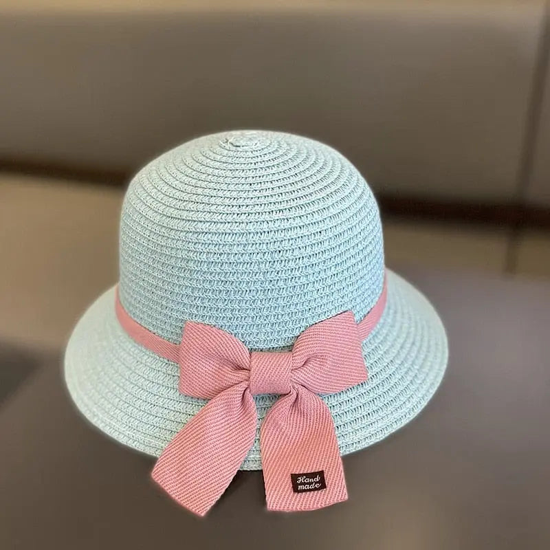 A light blue floral straw hat for girls (ages 2-8), featuring a wide brim and pink ribbon with "Hand made" label. Part of the Summer New Straw Bag Cap Set, ideal for travel or beach, displayed on a neutral background.