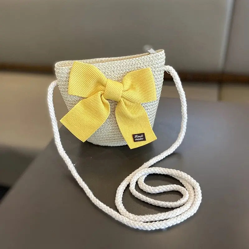 A charming set for kids aged 2-8: a beige woven crossbody straw bag with a large yellow bow and a matching floral sun hat—perfect summer accessories for travel or the beach, offering sun protection and style.