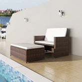 A two-piece brown poly rattan garden lounge set with white cushions beside a swimming pool.