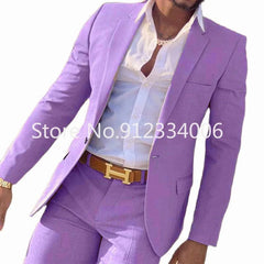 A man wears a slim-fit lavender suit with a white button-down shirt and a brown belt.