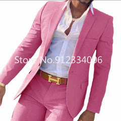 A man wears a slim-fit pink suit with a white button-down shirt and a brown belt.
