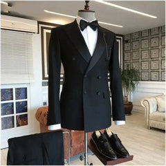 A black double-breasted tuxedo with a peaked lapel, white shirt, and bow tie on a mannequin.
