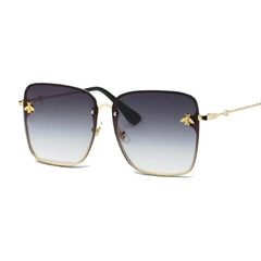 Square-framed sunglasses with gold metal rims, gradient lenses, and gold bee accents.