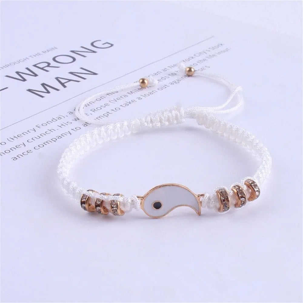 A white braided adjustable cord bracelet featuring a gold-edged yin yang fish charm and gold-accented beads. Perfect as 2022 Best Friend Matching Yin Yang Bracelets for BFF, friendship, relationship, boyfriend, or girlfriend.
