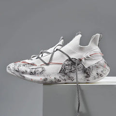 The 2022 Top Sale Fashion Sneaker features white mesh panels, black and gray abstract soles and sides, unique lacing, and red accents. These recycled men’s shoes are breathable, lightweight, with a modern look against a plain gray background.