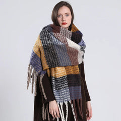 A woman wears a long, thick, multicolored plaid cashmere scarf with fringe tassels.