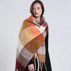 A woman wears a long, thick, multicolored plaid cashmere scarf with fringe tassels.