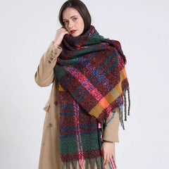 A woman wears a long, thick, multicolored plaid cashmere scarf with fringe tassels.