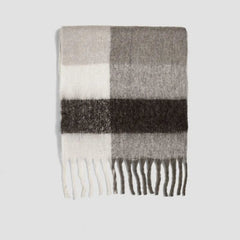 A long, thick cashmere-blend scarf featuring a grey, white, and black plaid pattern with tassels.