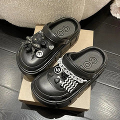 A pair of black platform clogs for women decorated with various charms and chains.