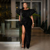 A woman wears a black sequin floor-length mermaid dress with puffed sleeves and a high side slit.