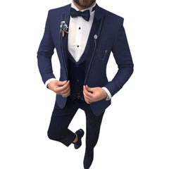 A man wears a navy blue three-piece suit with a white shirt and a matching bow tie.